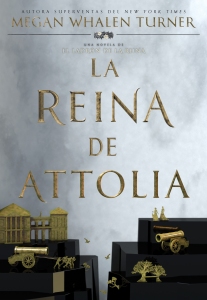 El título está escrito en letras doradas de estilo romano en un cielo gris sobre una maqueta de montañas negras y objetos dorados: un edificio, cañones y árboles.